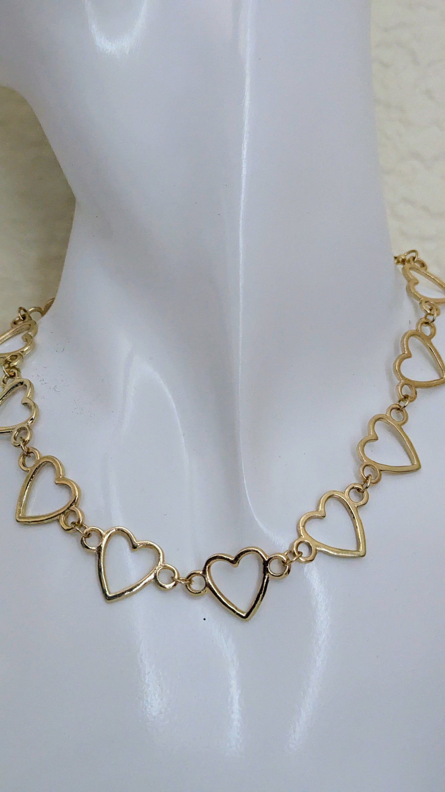 Gold heart-shaped bracelet on a white background
