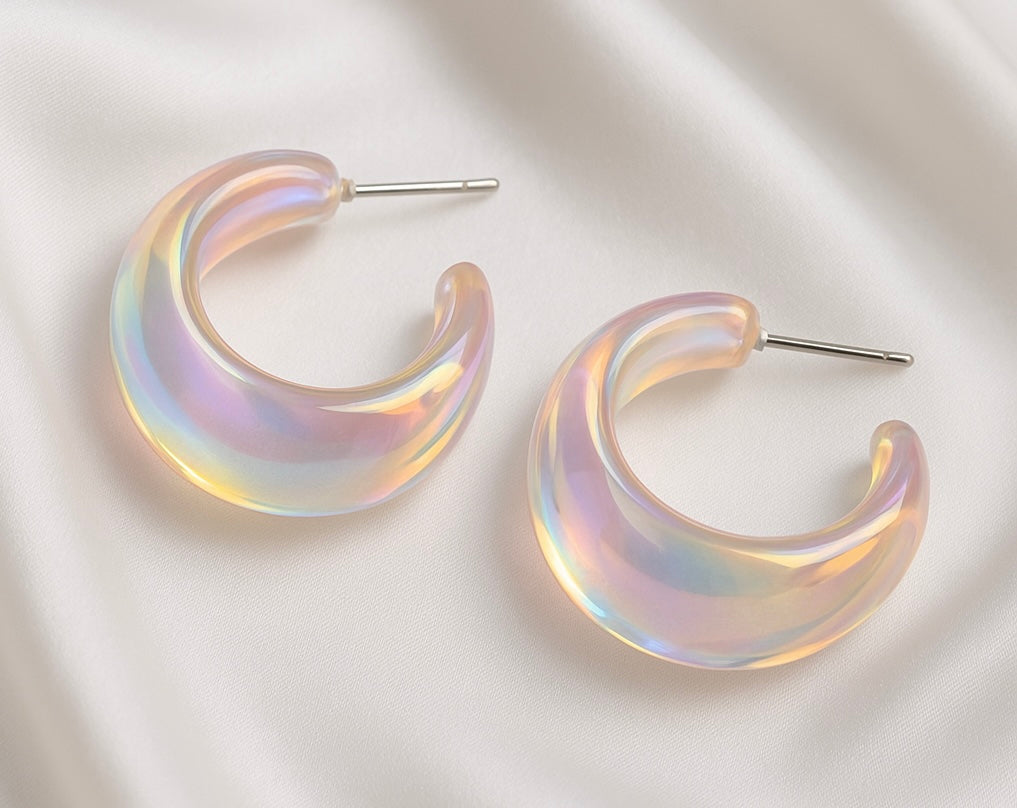 Iridescent crescent-shaped earrings on a light background