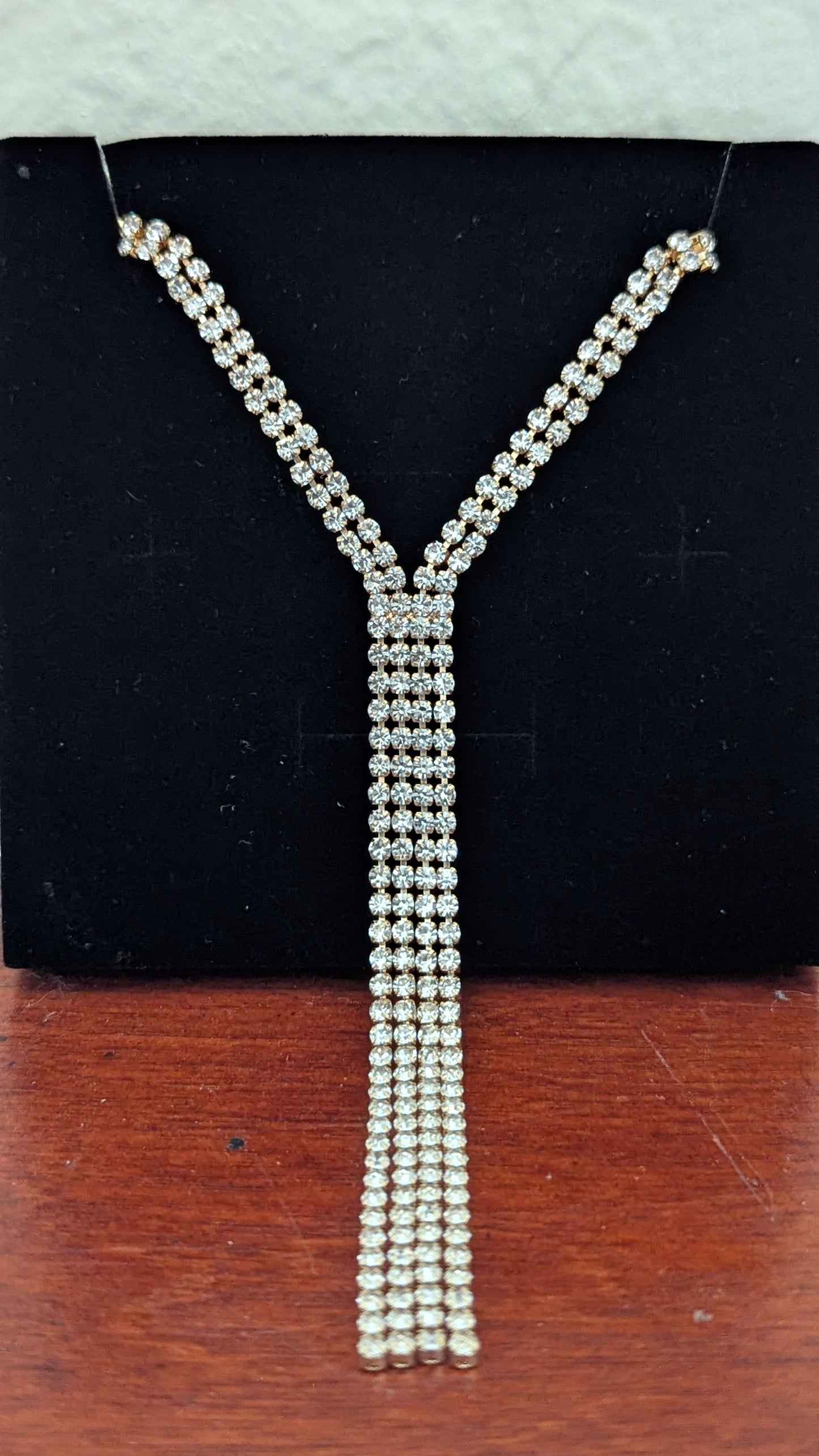 Pearl necklace on a black stand with a wooden surface below