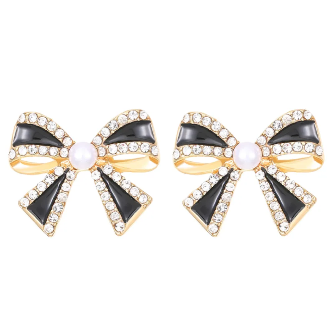 Bow-shaped earrings with gold, black, and pearl details on a white background