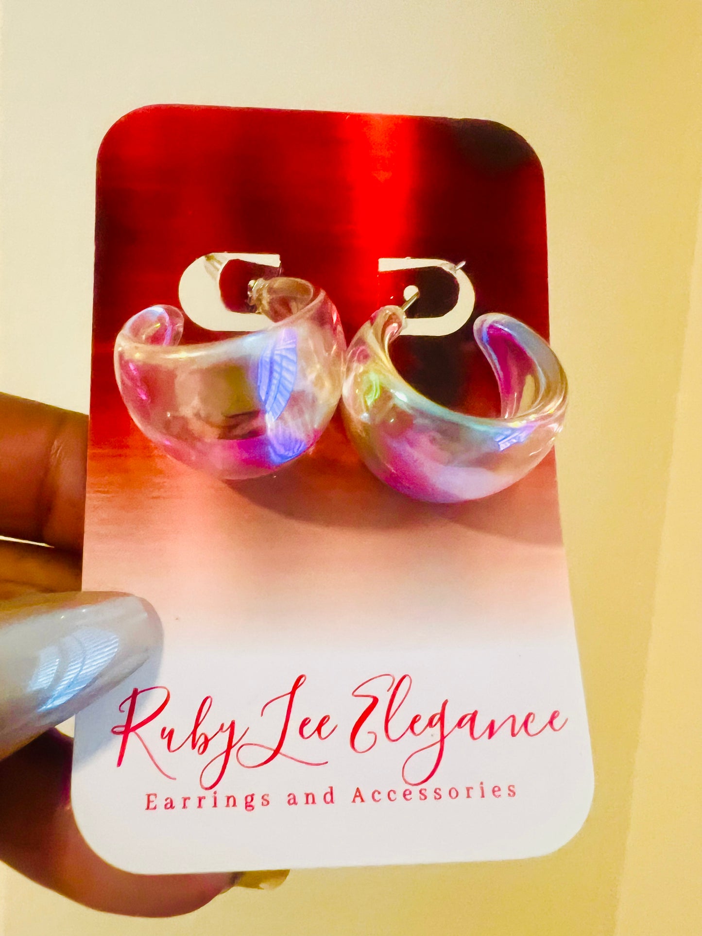 Colorful hoop earrings on a Ruby Lee Elegance card against a yellow background