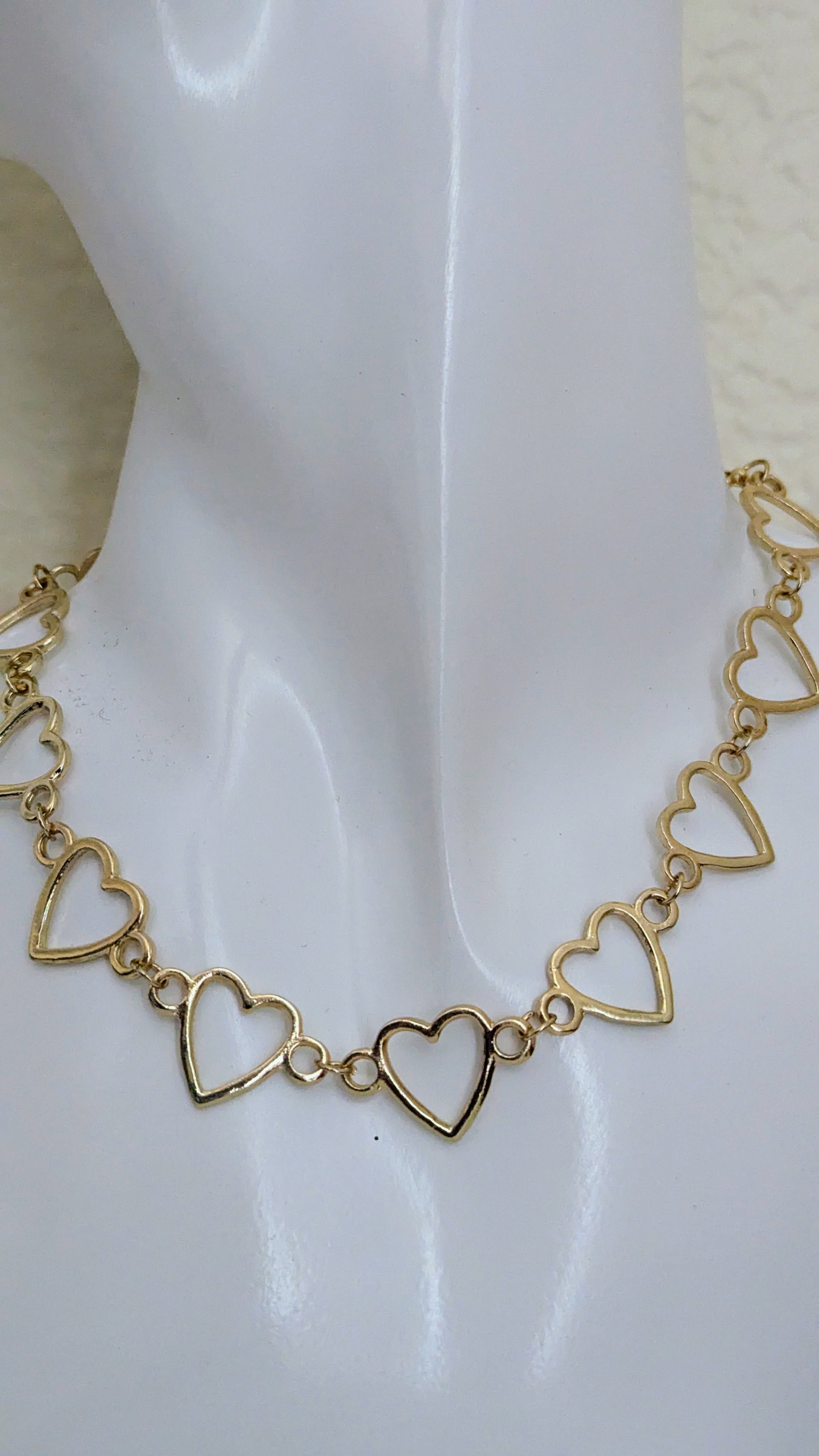 Gold heart-shaped bracelet on a white background
