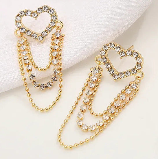 Gold heart-shaped earrings with chain details on a white background