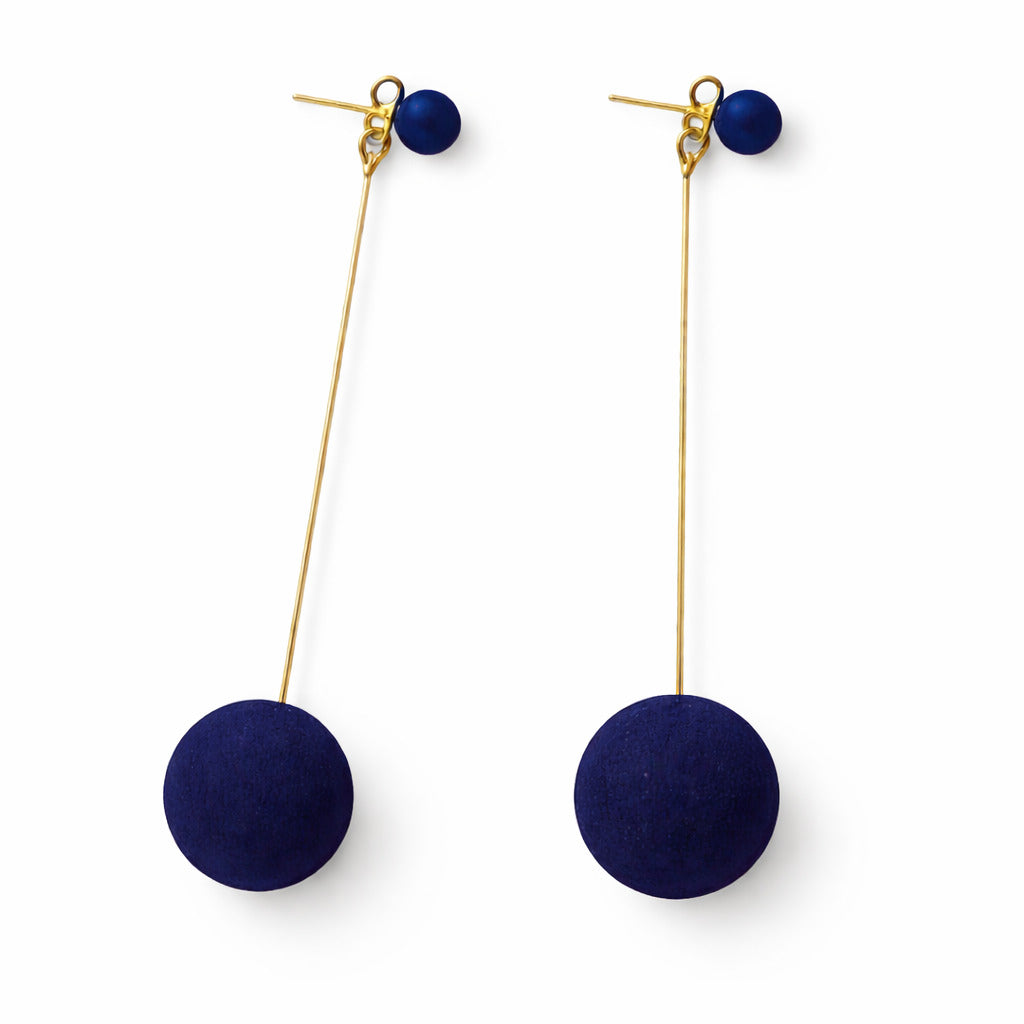 Pair of earrings with navy blue spherical pendants on gold hooks against a white background