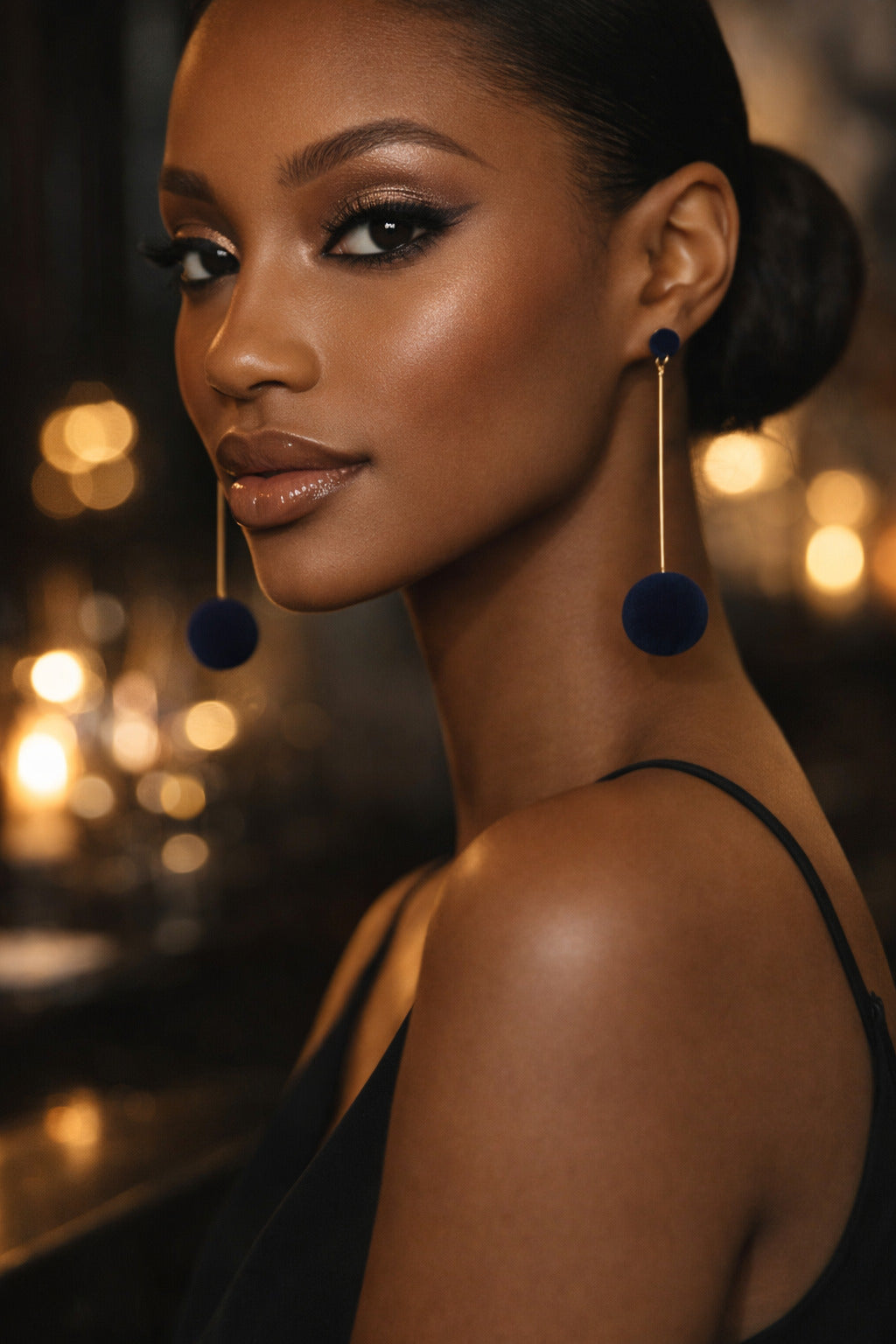 Woman wearing large blue earrings with a blurred background