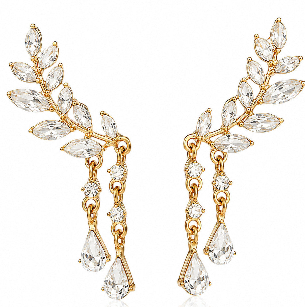 A pair of gold leaf-shaped drop earrings adorned with marquise and round clear crystals, shown against a plain white background.