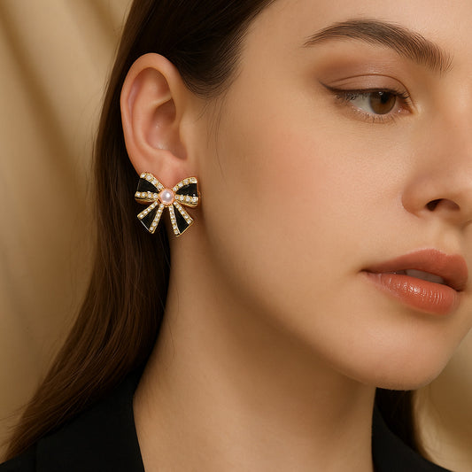 Close-up of a woman wearing a decorative bow-shaped earring with a beige background