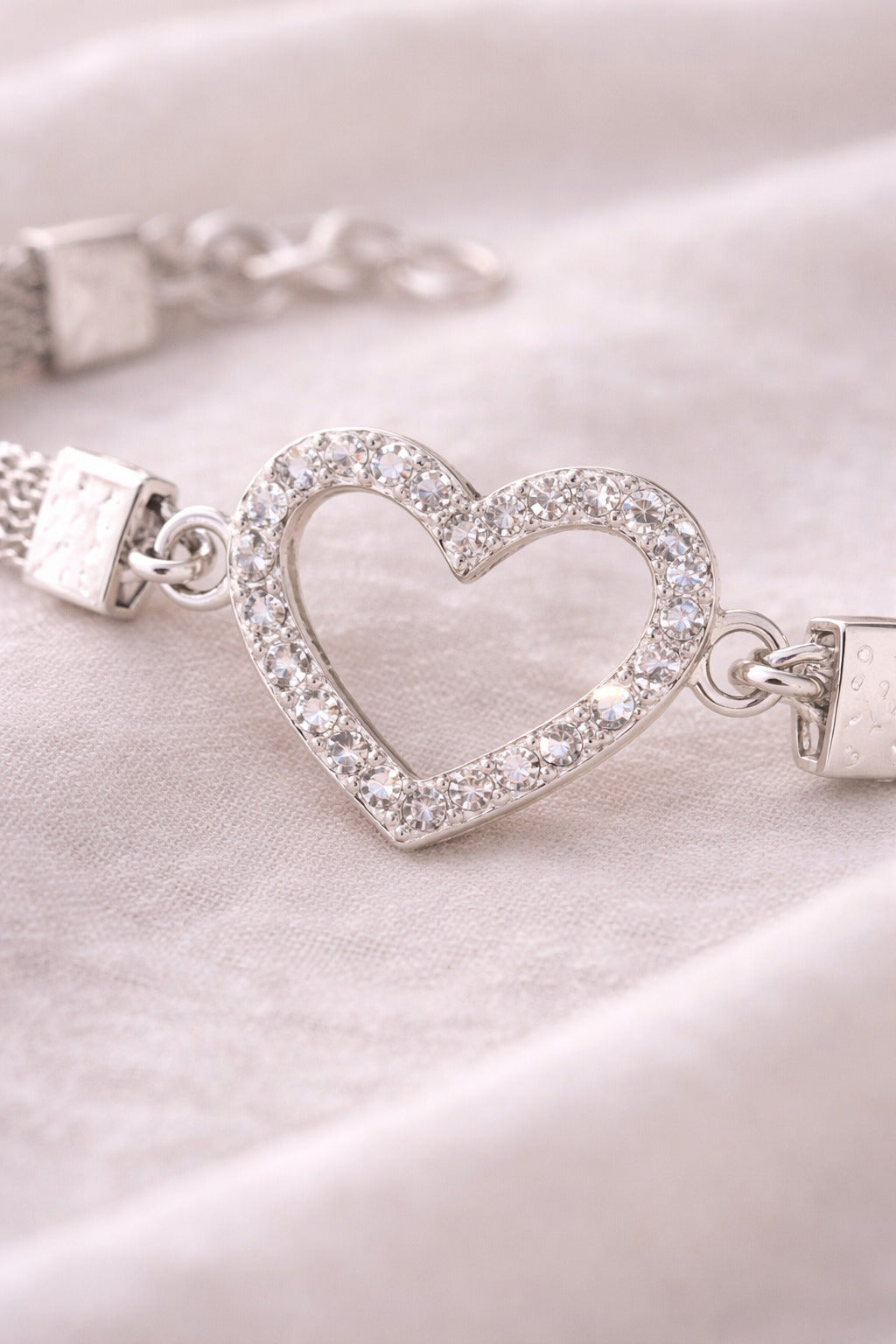 Silver bracelet with a heart-shaped clasp on a white background