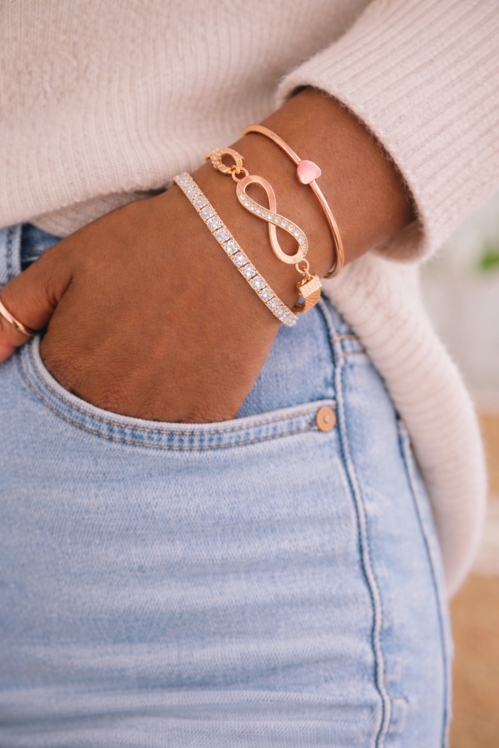 Close-up of a hand wearing multiple bracelets on a blurred background