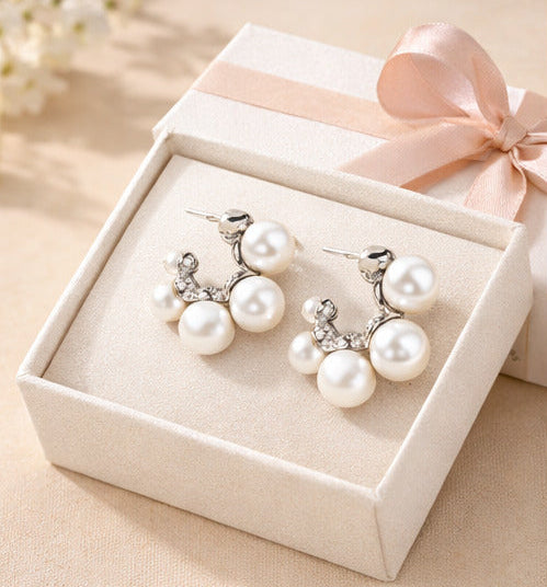 Four pairs of pearl earrings in different gift boxes with labels for traditional, affordable, luxurious, and romantic gifts.