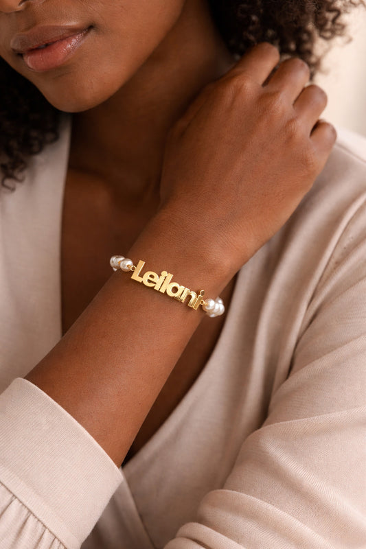 Gold bracelet with 'Leflori' branding on a person's wrist.