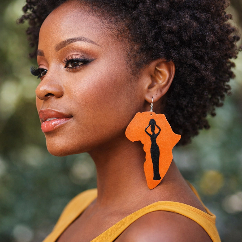 Woman wearing orange earrings with a silhouette design, outdoors.