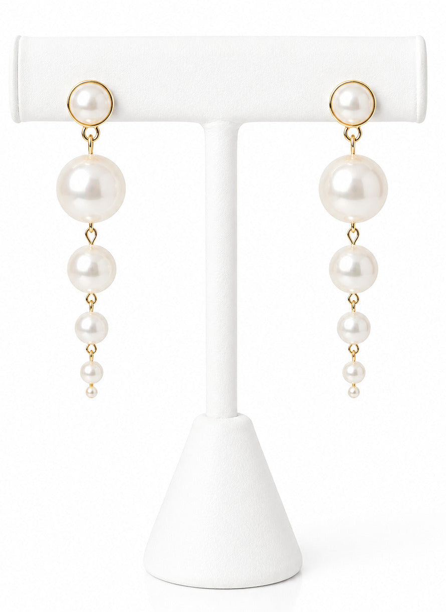 Pearl earrings on a white T-shaped stand