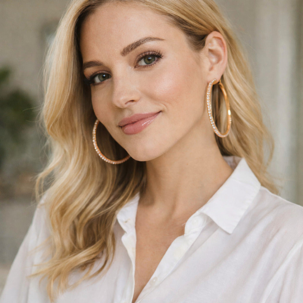 Woman wearing gold hoop earrings with a blurred background