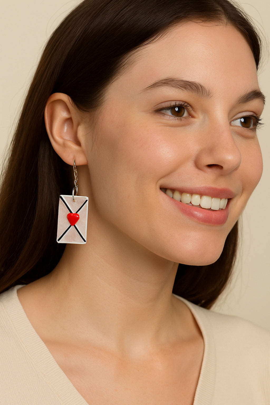 Woman wearing earrings with a heart design on a beige background