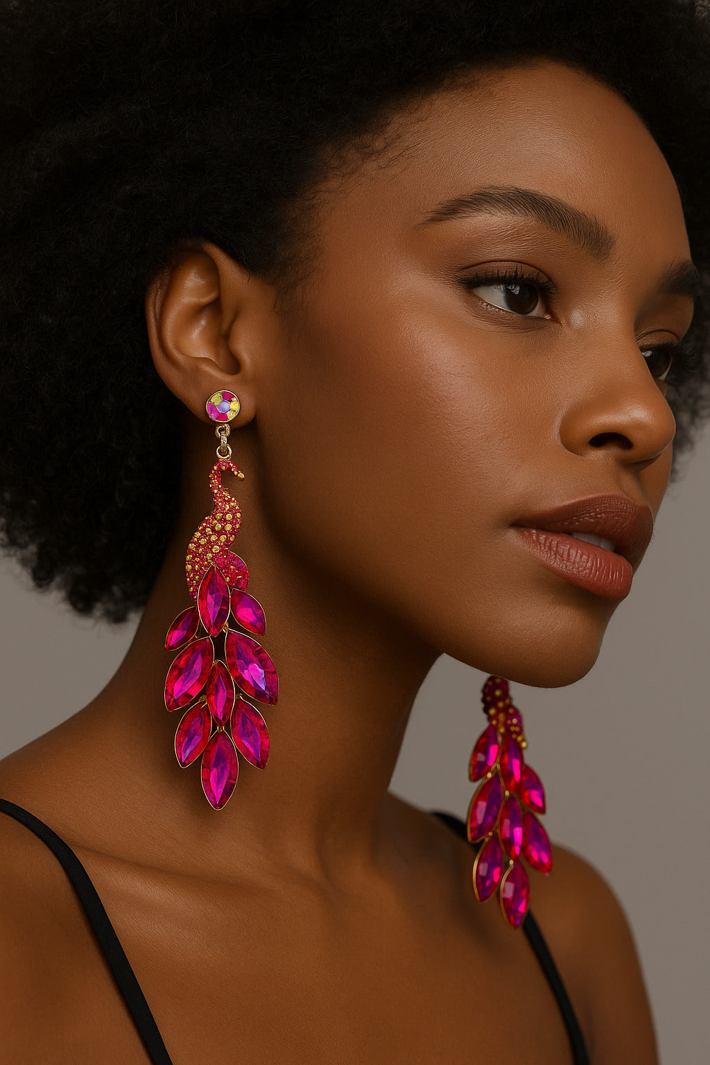 Woman wearing vibrant pink earrings against a neutral background