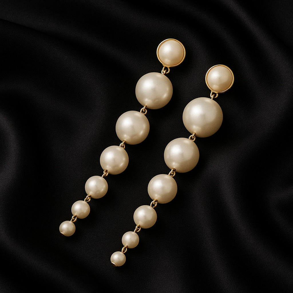 Pearl earrings on a black satin background