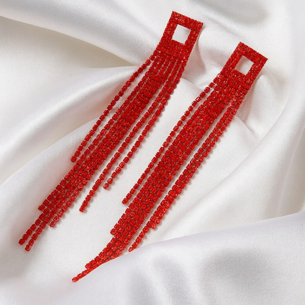 Red beaded earrings on a white fabric background