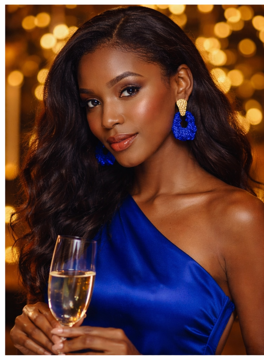 Woman in a blue dress holding a glass of champagne with a blurred bokeh background