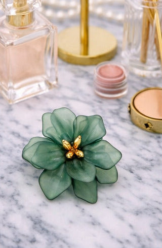 Green floral earrings on a woman with close-up shots of the earrings and a marble surface.