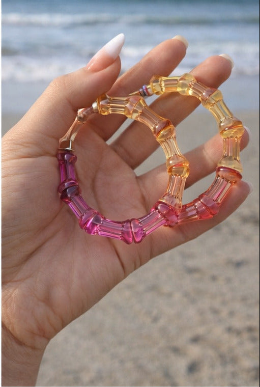 Collage of colorful hoop earrings worn by different people on a beach.