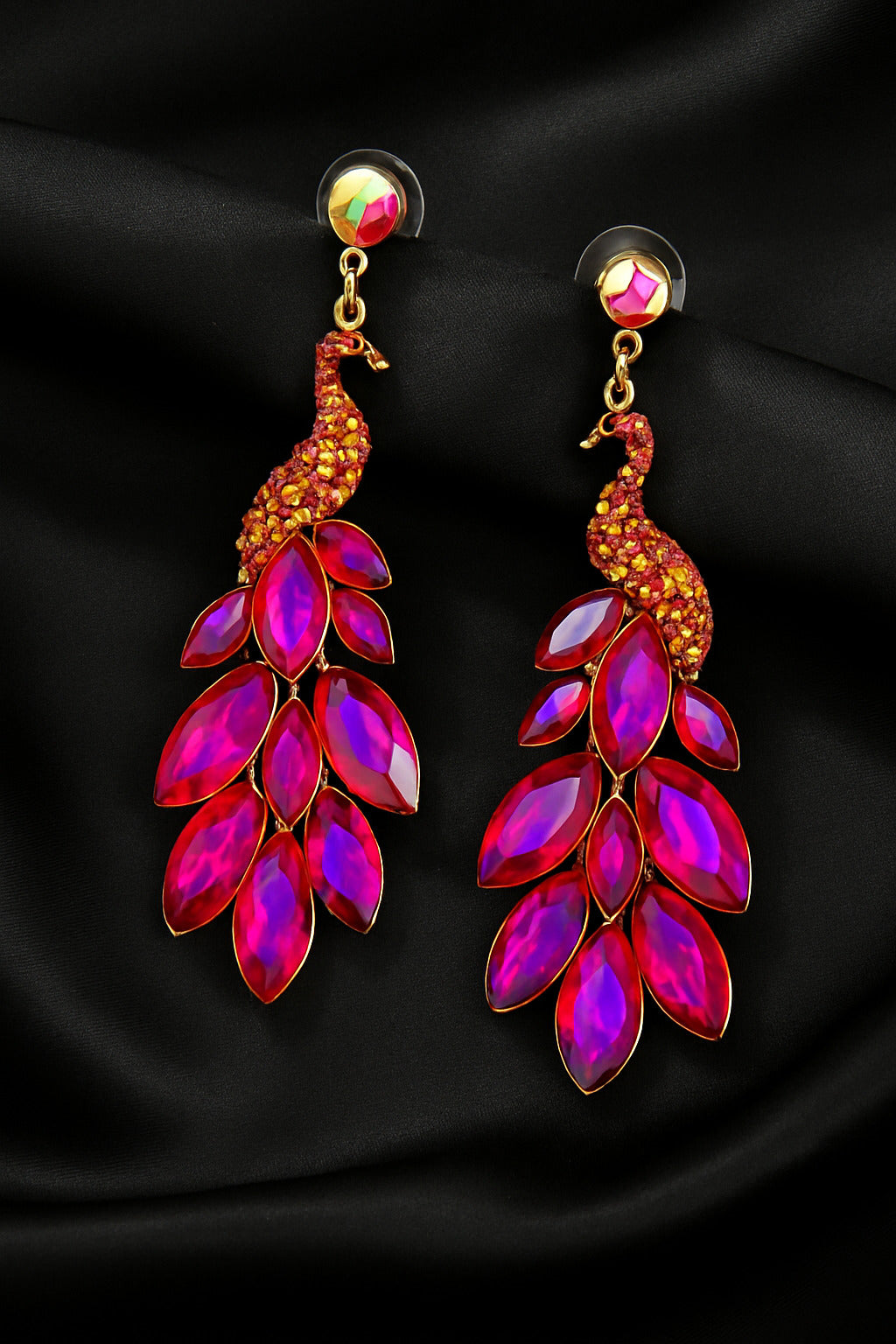 Pair of peacock-shaped earrings with red and gold details on a black background