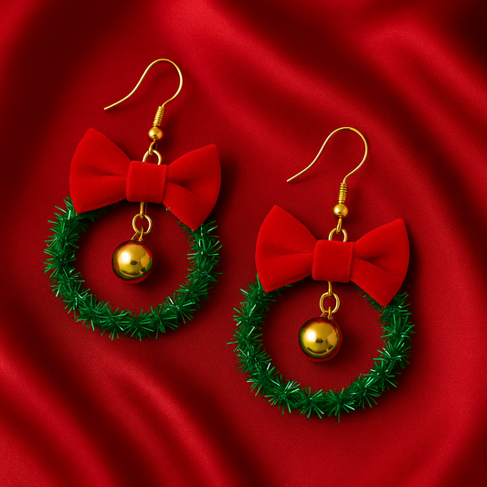 Christmas-themed earrings with red bows and green wreaths on a red fabric background