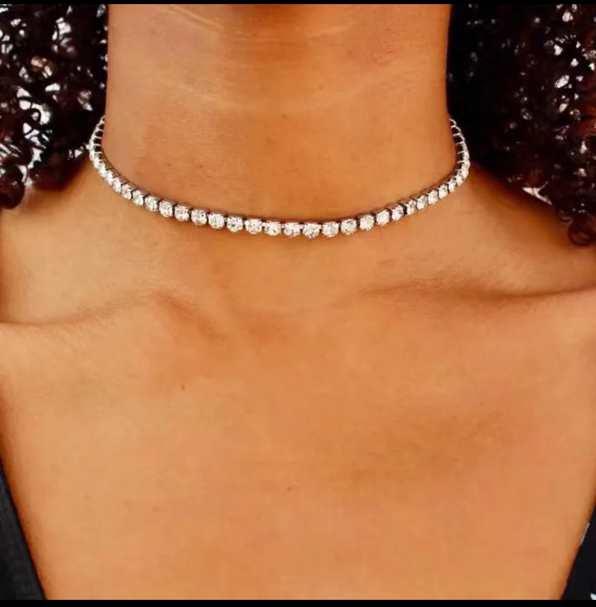 Silver necklace with small round beads on a person's neck