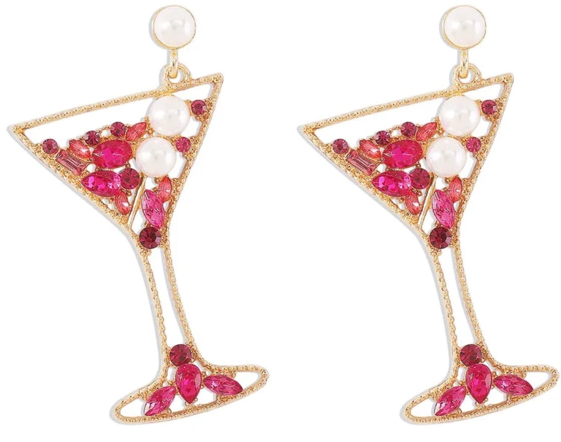 Earrings designed like martini glasses with pink gemstones and pearls on a white background