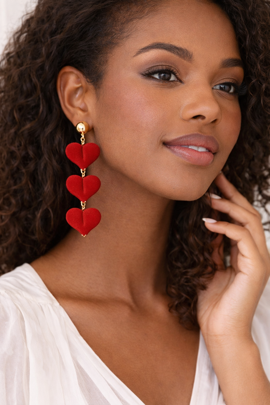 Woman wearing red heart-shaped earrings with a white top