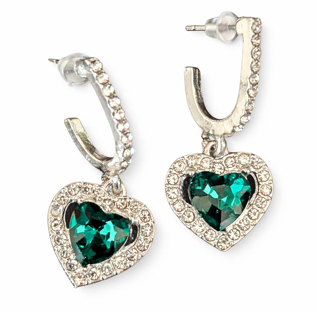 Heart-shaped earrings with green gemstones on a white background