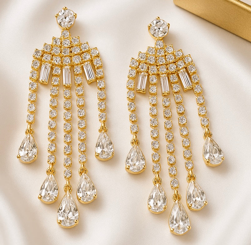 Gold and crystal chandelier earrings on a light background