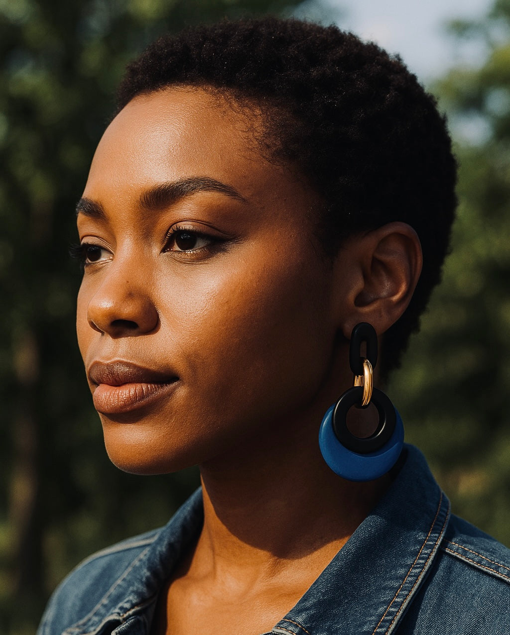 Woman wearing blue earrings with a blurred natural background