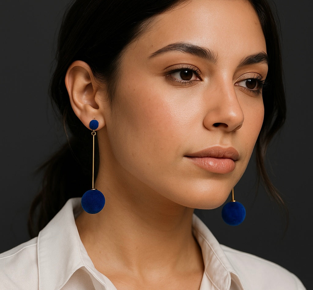 Woman wearing blue earrings against a dark background