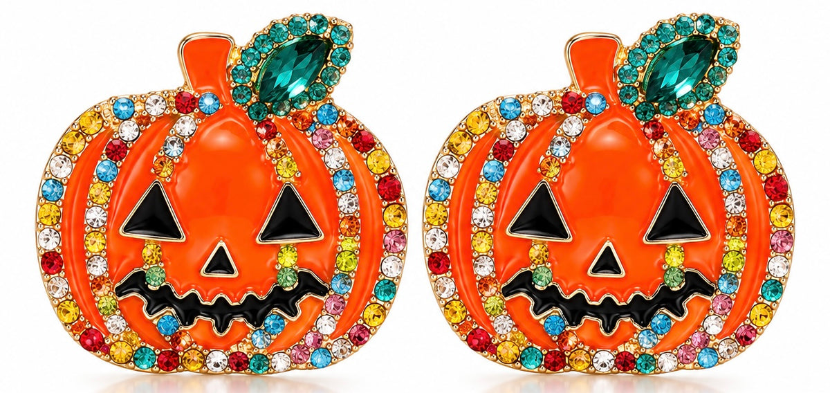 A pair of orange jack-o'-lantern-shaped earrings embellished with multicolored rhinestones, featuring black triangular eyes and mouth details, and green teardrop-shaped stones at the top, set against a plain white background.