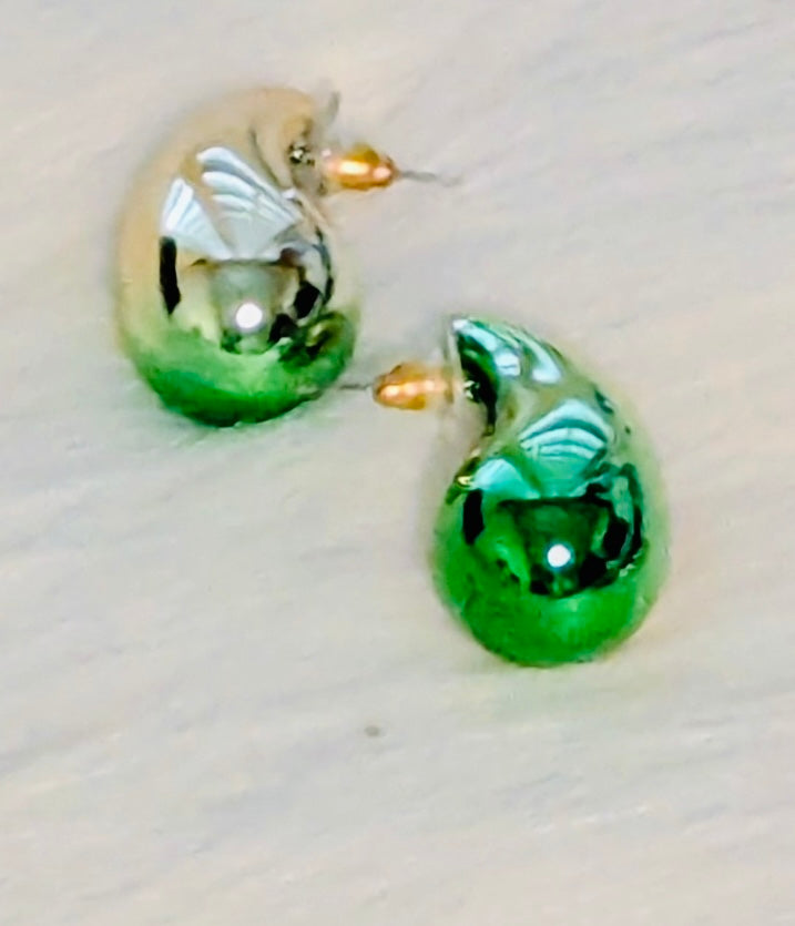 Green teardrop-shaped earrings on a light background