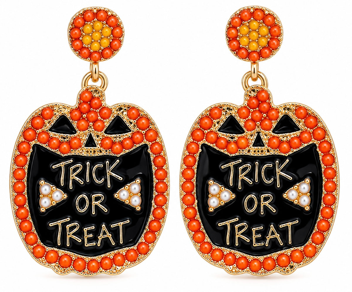 A pair of Halloween dangle earrings featuring jack-o'-lantern shapes with black enamel, orange rhinestone borders, and the words 'TRICK OR TREAT' in gold lettering. The top studs are decorated with orange and yellow rhinestones.