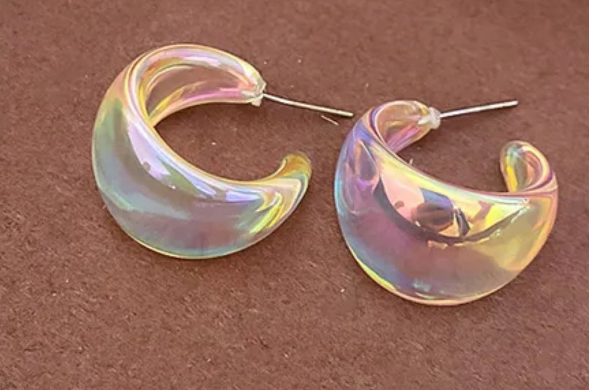 Iridescent hoop earrings on a brown background