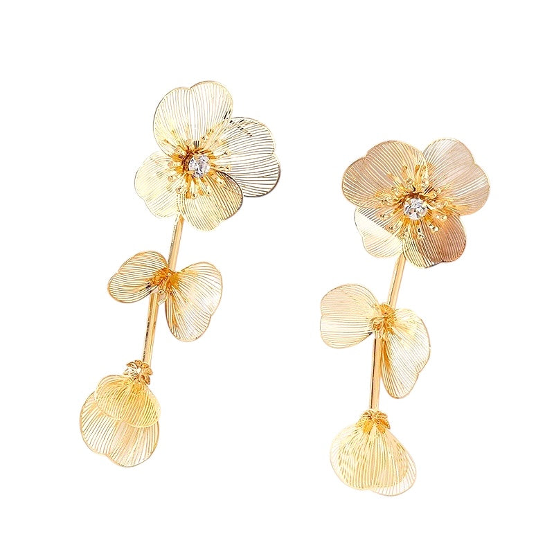 Gold floral earrings on a white background
