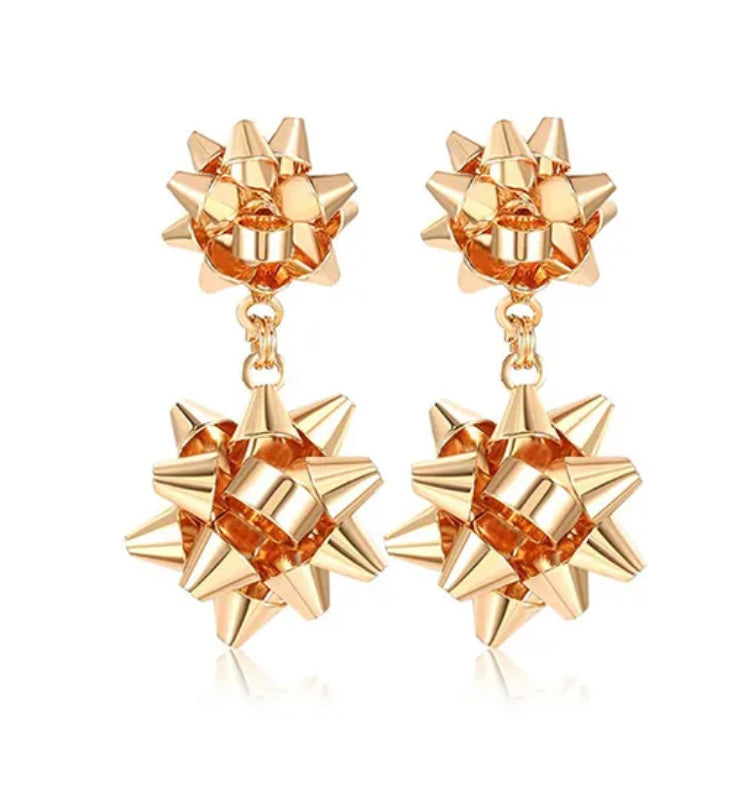 Gold ribbon shaped earrings on a white background
