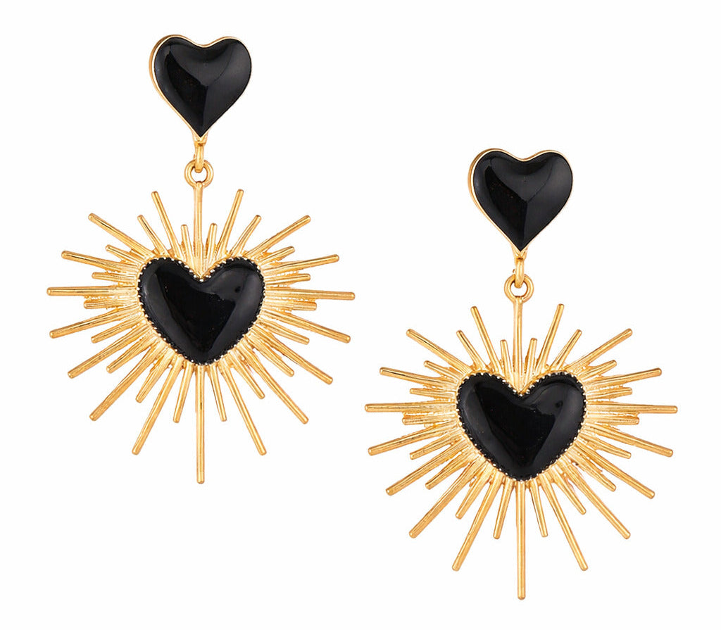 Pair of earrings with black heart-shaped drops and gold sunburst designs on a white background