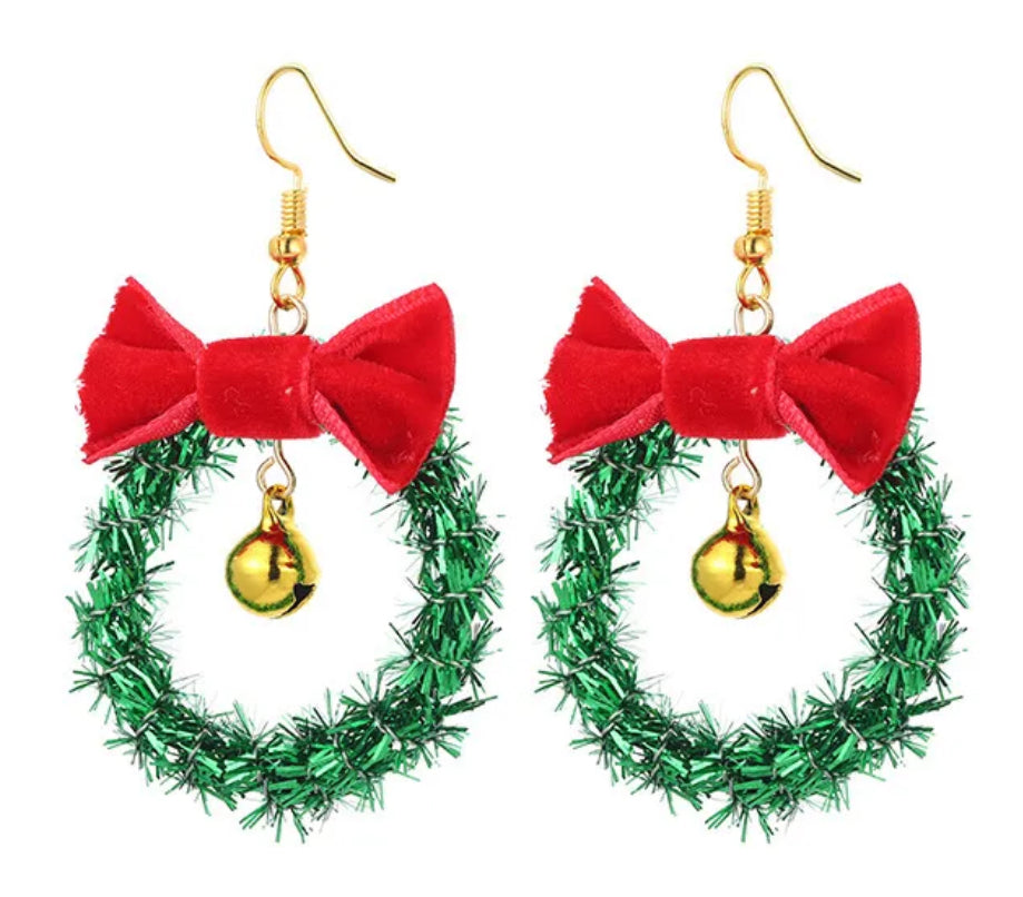 Christmas-themed earrings with green wreath and red bow design on a white background