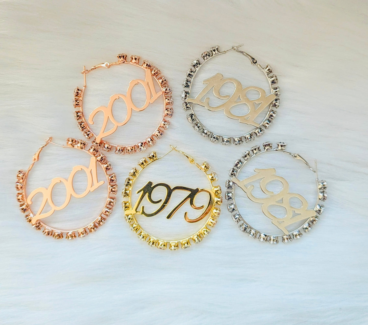 Set of five hoop earrings with numbers '2001', '1989', '1979' on a light background