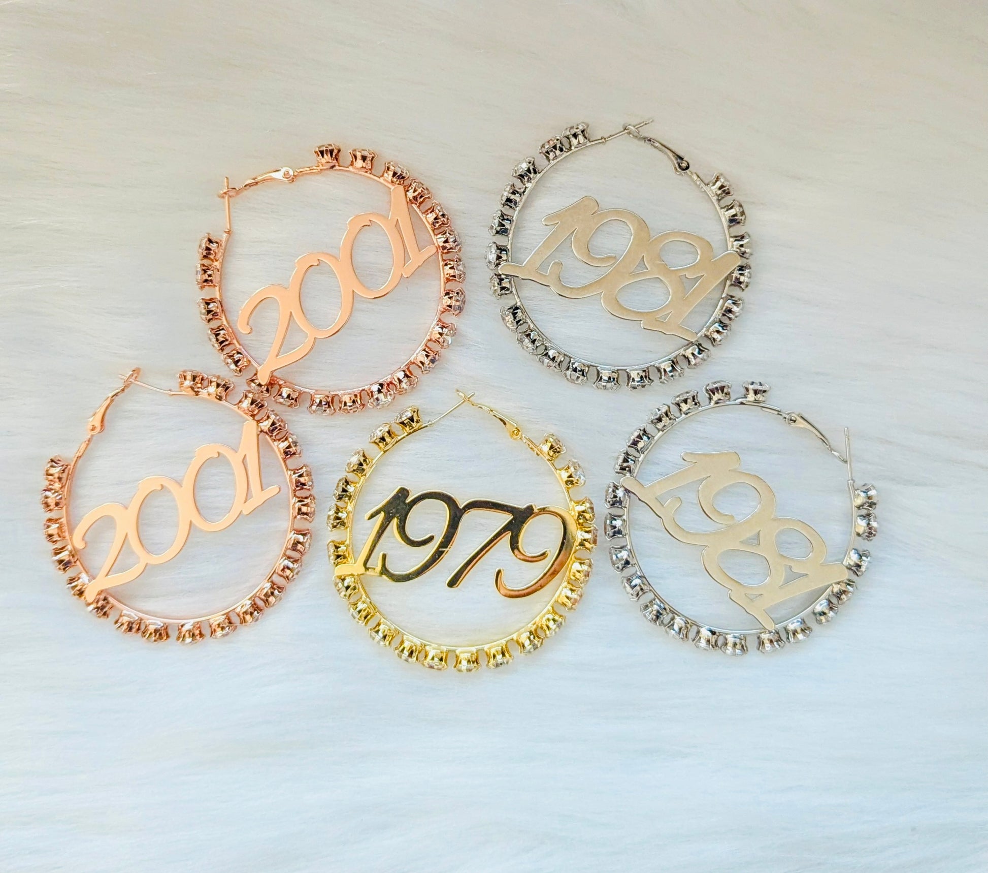 Set of five hoop earrings with numbers '2001', '1989', '1979' on a light background