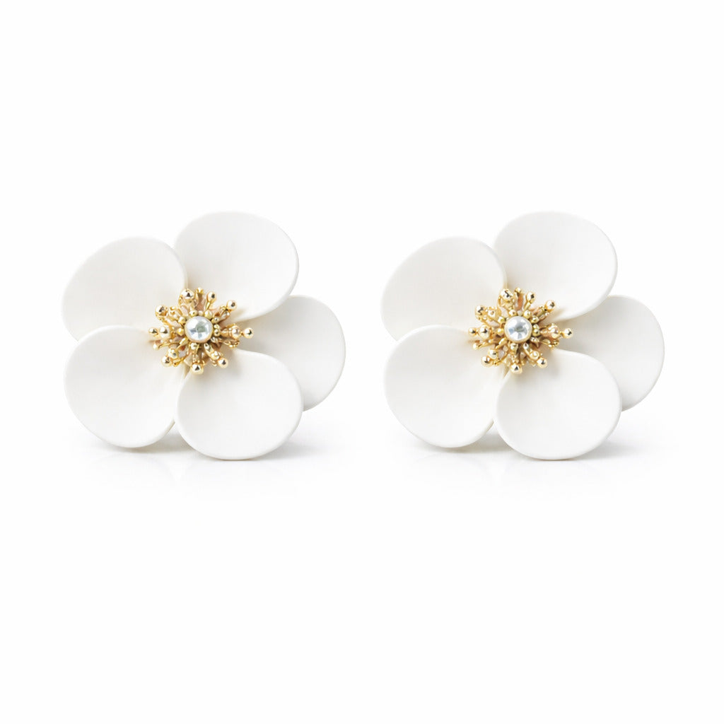 Pair of white flower-shaped earrings with gold centers on a white background