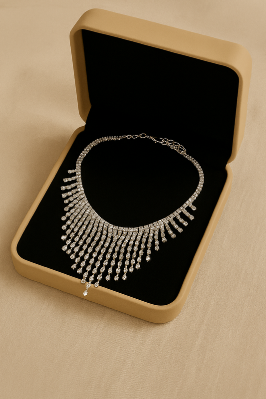 Silver necklace in an open jewelry box on a beige surface
