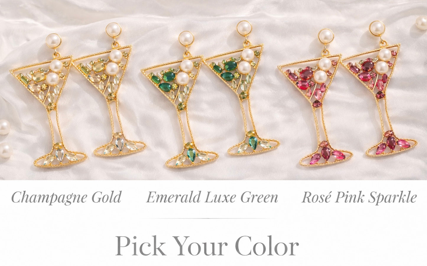 Set of earrings shaped like cocktail glasses with gemstones on a textured white background.