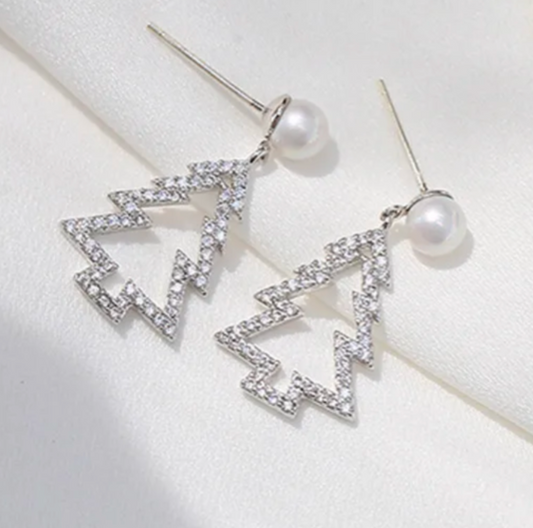 Silver earrings with geometric design and pearls on a white surface