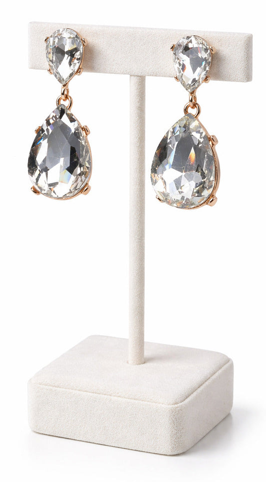 Teardrop-shaped earrings on a white stand with a white background