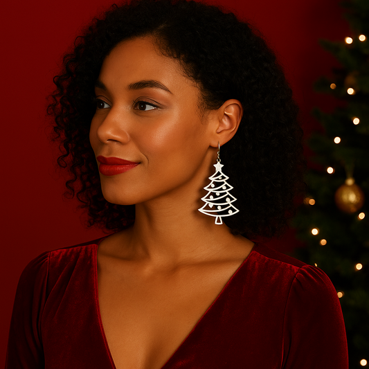 Woman wearing a Christmas tree earring with a red background and Christmas tree decorations.